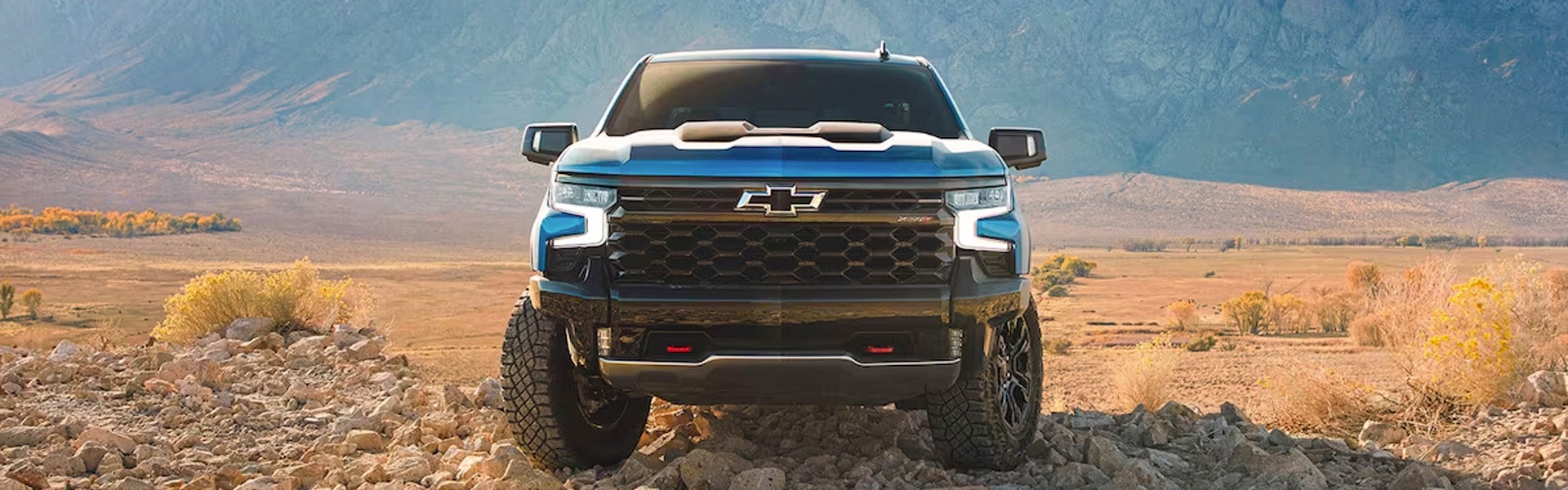 Blue Silverado 1500 running off-roading in mountain area
