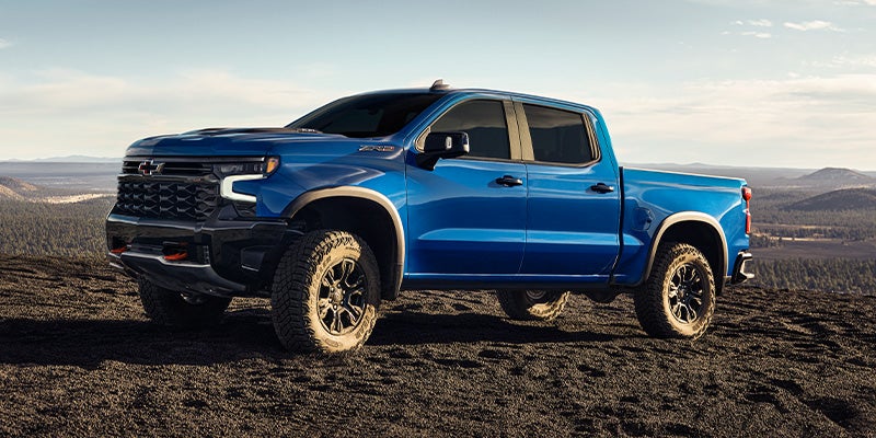 Blue silverado standing in desert area
