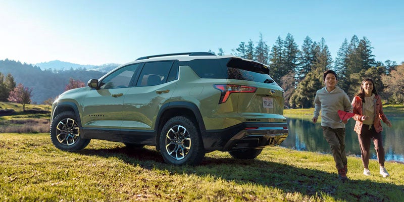 Green chevy Equinox standing near lake children's around