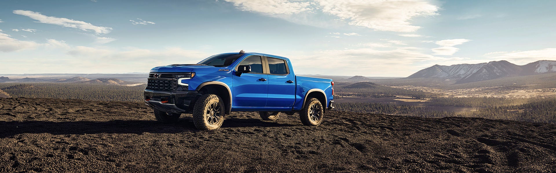 Blue silverado standing in desert area